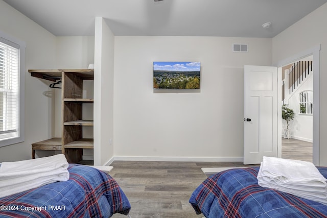 bedroom featuring wood finished floors, visible vents, and baseboards