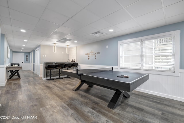 rec room featuring visible vents, a drop ceiling, a wainscoted wall, wood finished floors, and recessed lighting