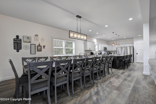 dining room with baseboards, wood finished floors, and recessed lighting