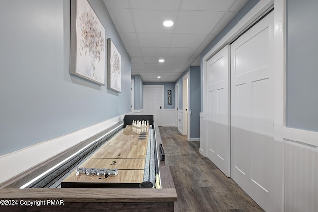 rec room featuring a bowling alley, a drop ceiling, wood finished floors, and recessed lighting