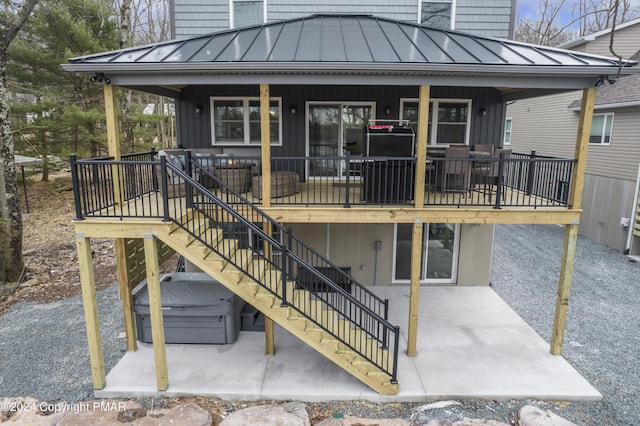 rear view of house with stairs, metal roof, a standing seam roof, and a patio