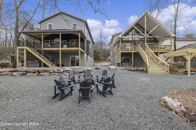 rear view of house featuring an outdoor fire pit, stairway, and a wooden deck