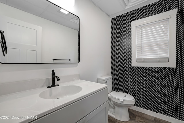 bathroom featuring tiled shower, a drop ceiling, vanity, and toilet