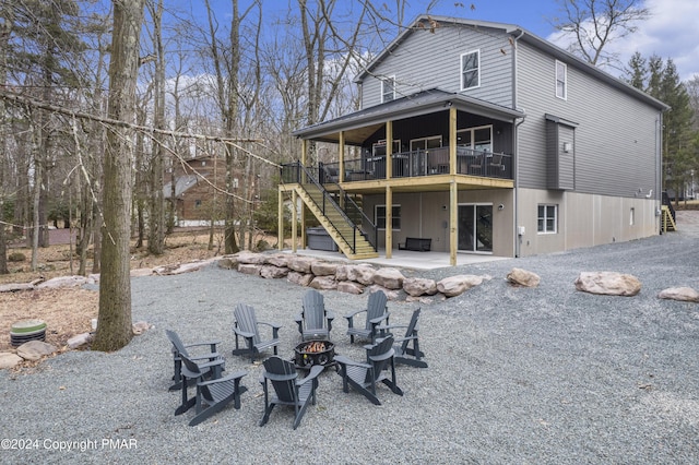 back of property with an outdoor fire pit, stairway, a deck, and a patio