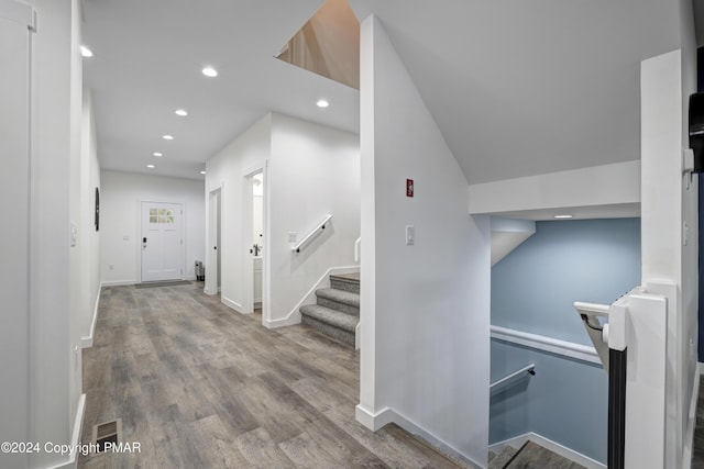 interior space with baseboards, stairway, wood finished floors, and recessed lighting