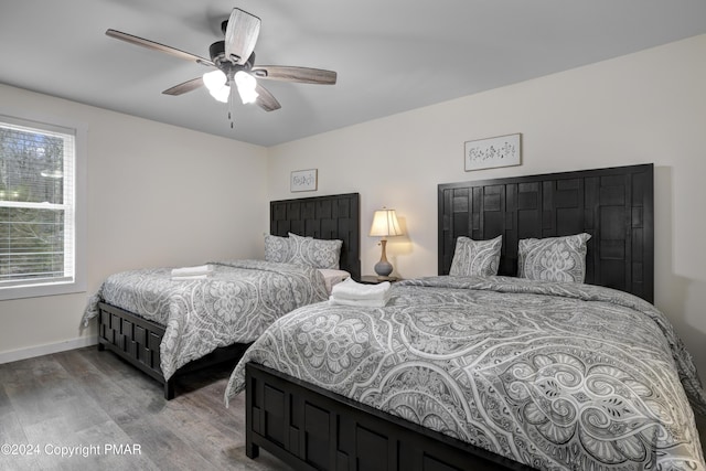 bedroom with ceiling fan, baseboards, and wood finished floors