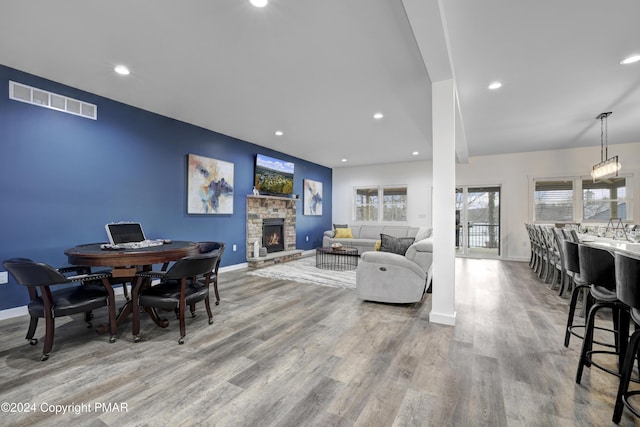 living room featuring recessed lighting, visible vents, a fireplace, and wood finished floors