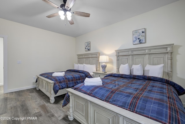 bedroom with ceiling fan, baseboards, and wood finished floors