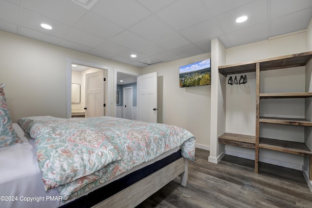 bedroom with a paneled ceiling, baseboards, dark wood finished floors, and recessed lighting