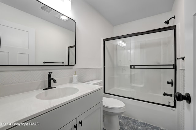 bathroom with toilet, shower / bath combination with glass door, visible vents, and vanity