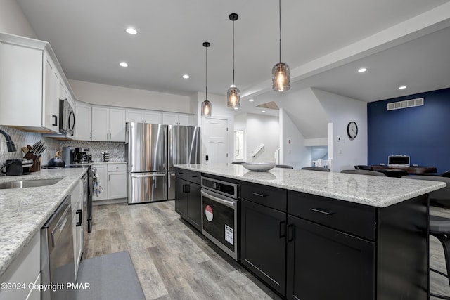 kitchen with appliances with stainless steel finishes, white cabinets, visible vents, and dark cabinetry