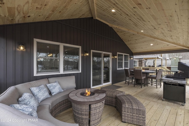 wooden deck featuring outdoor dining area and an outdoor living space with a fire pit