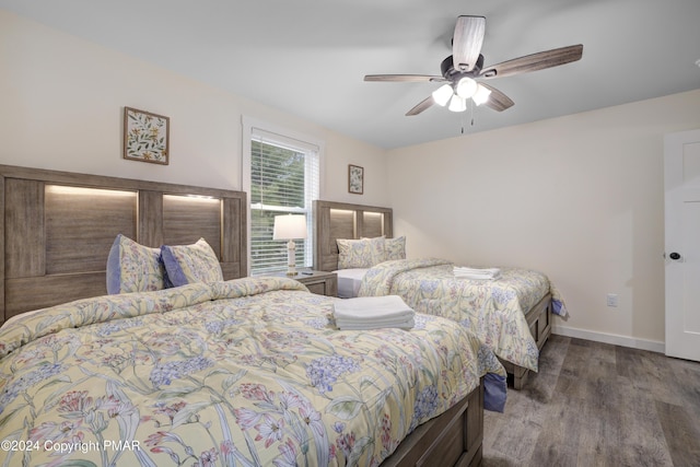 bedroom with ceiling fan, baseboards, and wood finished floors