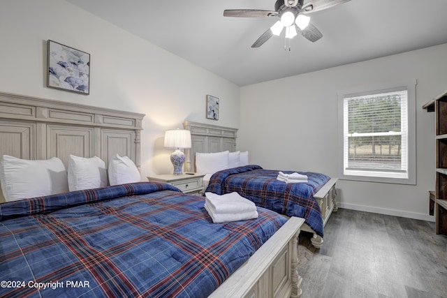 bedroom with a ceiling fan, baseboards, and wood finished floors