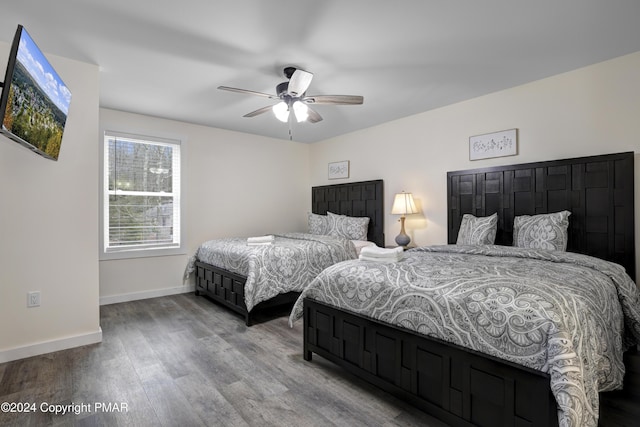 bedroom featuring wood finished floors, a ceiling fan, and baseboards