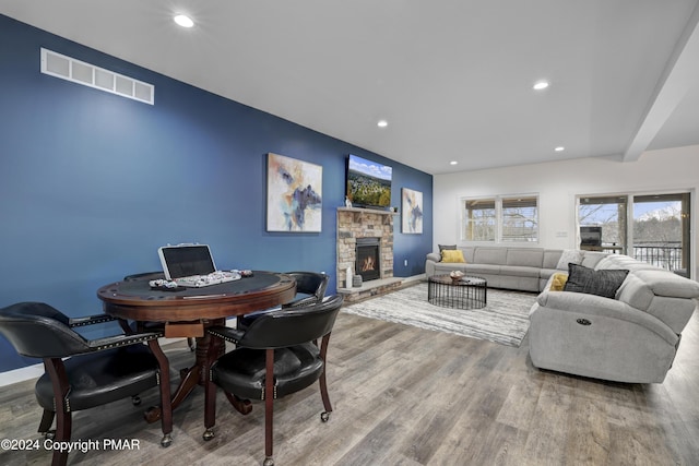 interior space featuring a stone fireplace, wood finished floors, visible vents, and recessed lighting