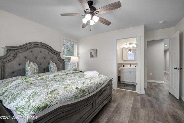 bedroom featuring dark wood-type flooring, a ceiling fan, connected bathroom, a sink, and baseboards