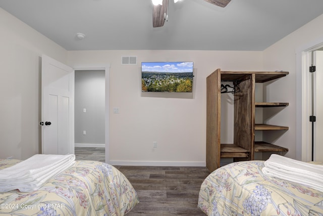 bedroom with a ceiling fan, baseboards, visible vents, and wood finished floors