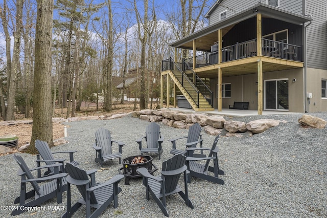 rear view of house featuring a patio, a fire pit, a wooden deck, and stairs