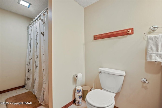 bathroom with tile patterned flooring, a shower with curtain, baseboards, and toilet