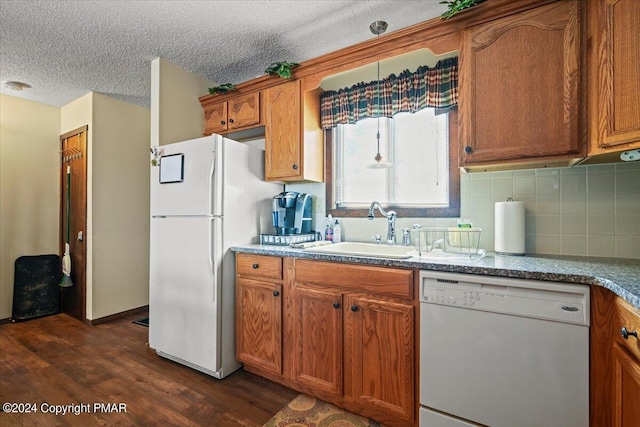 kitchen with white appliances, brown cabinets, and a sink