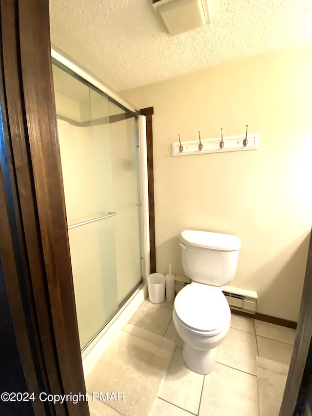 bathroom with toilet, a baseboard radiator, tile patterned flooring, and a shower stall