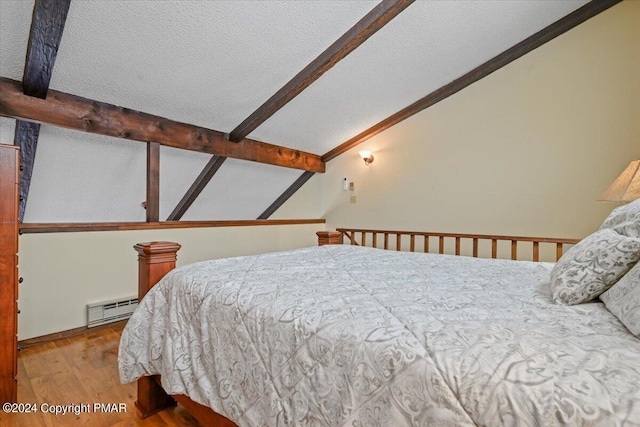 bedroom featuring lofted ceiling with beams, a textured ceiling, a baseboard heating unit, and wood finished floors