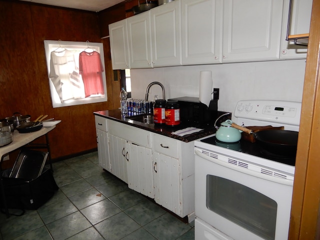 kitchen featuring white cabinetry, white electric range oven, dark countertops, and a sink