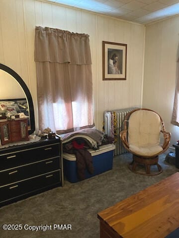 living area featuring dark colored carpet and radiator heating unit