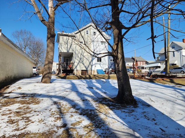 yard covered in snow featuring a residential view