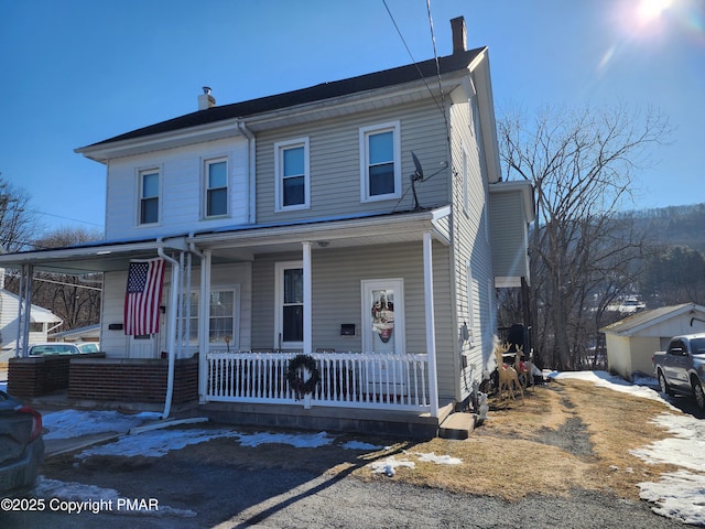 view of front of home with covered porch and a chimney