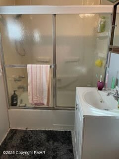 bathroom featuring combined bath / shower with glass door and vanity