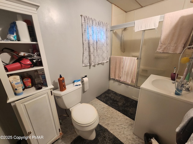 full bath with toilet, vanity, and a shower with door