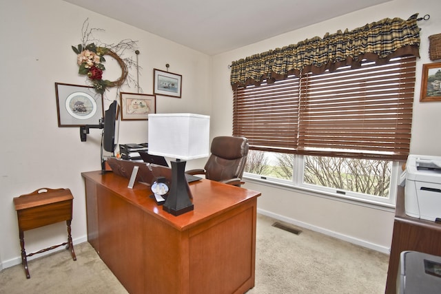 office area with visible vents, baseboards, and light carpet