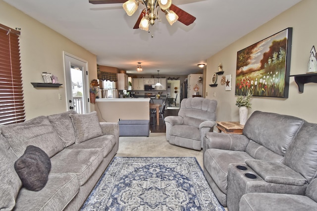 living room with a ceiling fan and light carpet