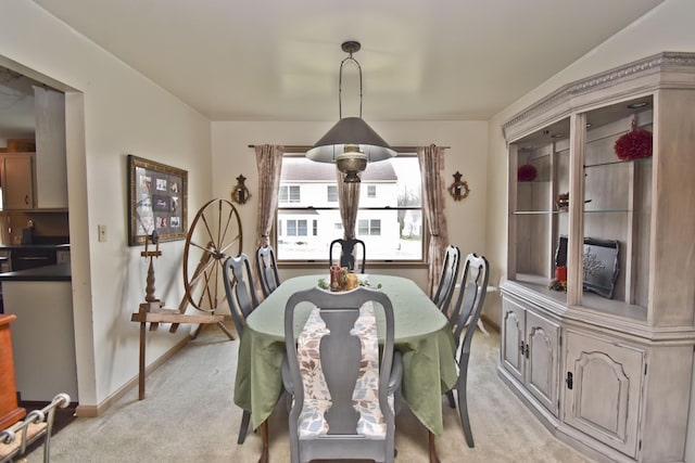 dining room with baseboards and light colored carpet