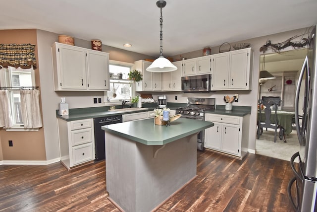 kitchen with a sink, stainless steel appliances, white cabinetry, and dark countertops