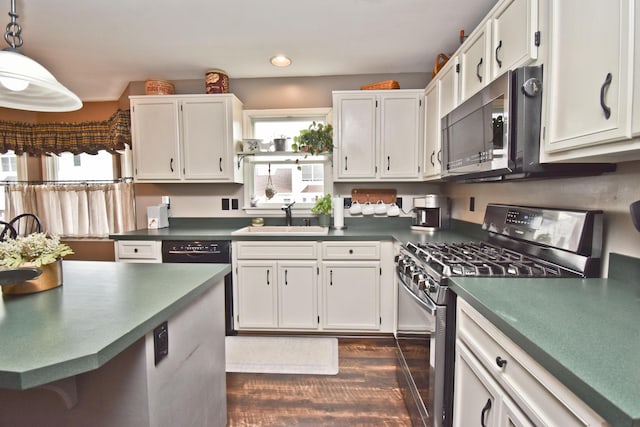 kitchen featuring white cabinetry, stainless steel appliances, dark wood-style floors, and a sink