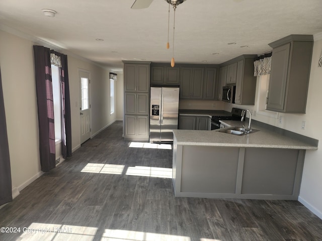 kitchen featuring a peninsula, appliances with stainless steel finishes, dark wood-style floors, and gray cabinetry