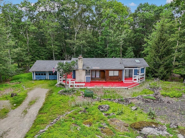 250 Sunrise Loop, Henryville, PA 18332 - view of front facade with driveway, a forest view, a garage, and a chimney