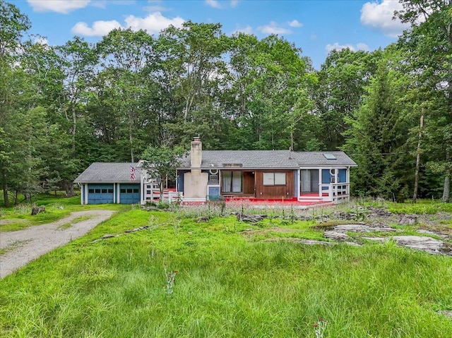 250 Sunrise Loop, Henryville, PA 18332 - view of front of house featuring a garage, driveway, a chimney, and a forest view