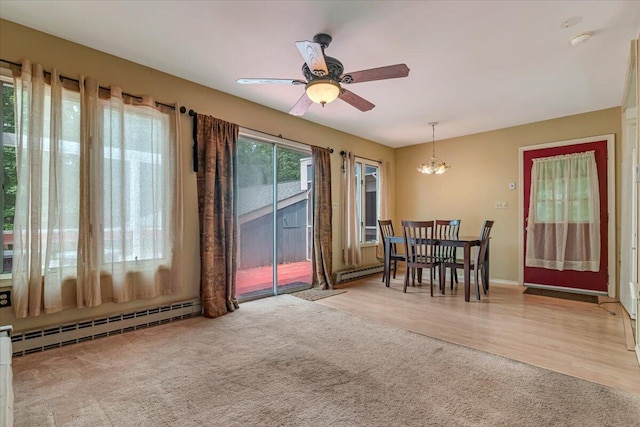 250 Sunrise Loop, Henryville, PA 18332 - carpeted dining room with a baseboard heating unit, a ceiling fan, a chandelier, and wood finished floors