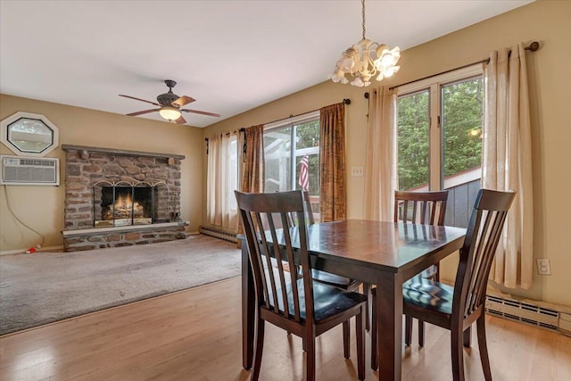 250 Sunrise Loop, Henryville, PA 18332 - dining room featuring a wall mounted AC, a chandelier, light wood finished floors, a fireplace, and a ceiling fan