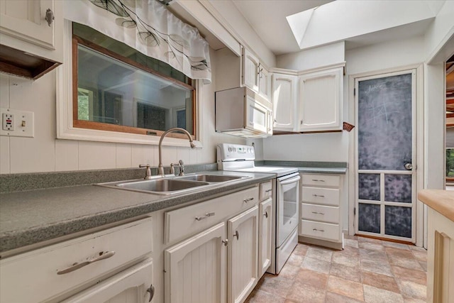 250 Sunrise Loop, Henryville, PA 18332 - kitchen with white appliances, a skylight, stone finish floors, and dark countertops
