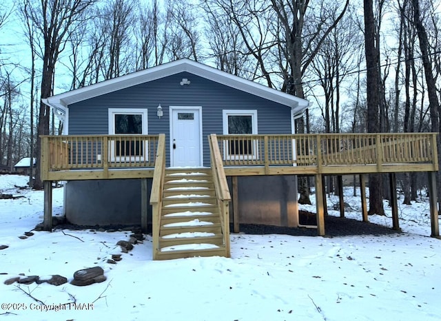 view of front of house with a garage, a wooden deck, and stairs