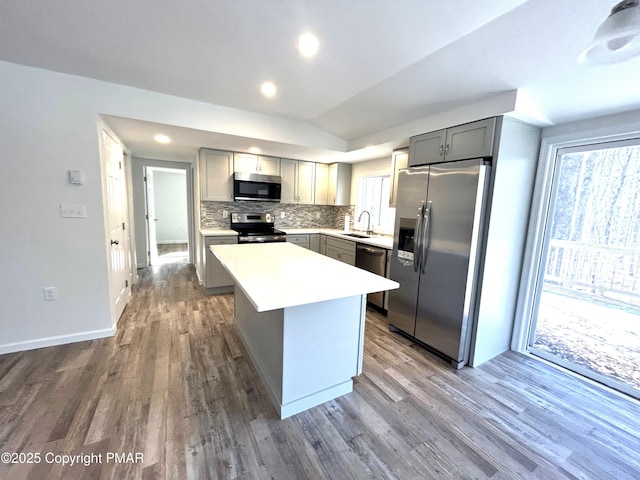 kitchen with stainless steel appliances, gray cabinets, light countertops, and a sink