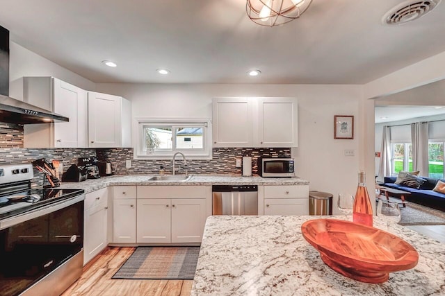 134 Altemose Rd, Pocono Lake, PA 18347 - kitchen with wall chimney range hood, a sink, light wood-style floors, stainless steel appliances, and visible vents