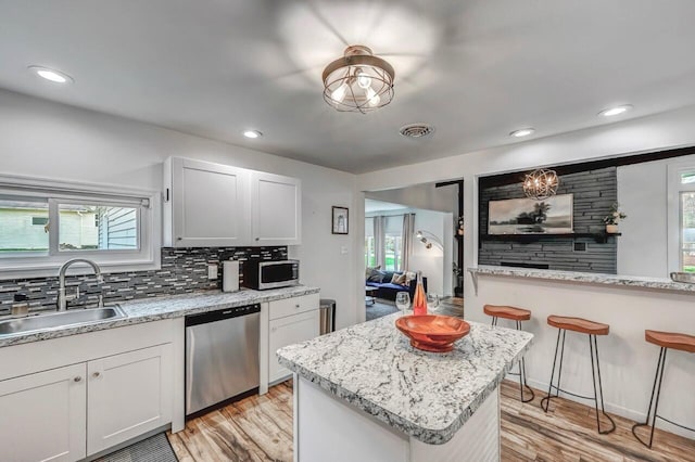134 Altemose Rd, Pocono Lake, PA 18347 - kitchen with a kitchen island, backsplash, a sink, light wood-style floors, and stainless steel appliances