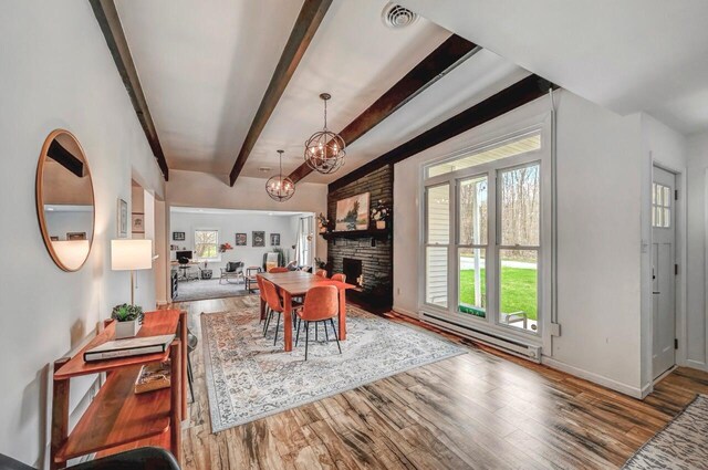 134 Altemose Rd, Pocono Lake, PA 18347 - dining area featuring an inviting chandelier, baseboard heating, beam ceiling, wood finished floors, and visible vents