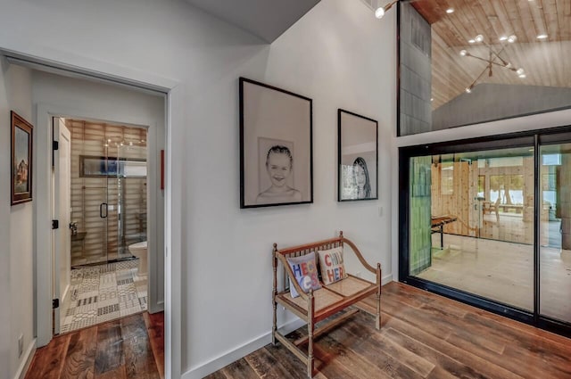 doorway featuring baseboards, wood finished floors, and lofted ceiling